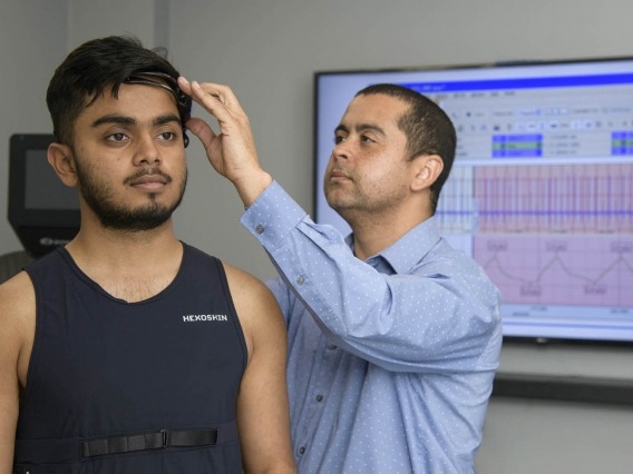 a researcher working with a sensor on a study participant